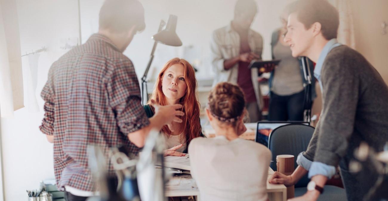 Ein Team junger Fachkräfte arbeitet in einem hellen Büro gemeinsam an einem Projekt zur kommunalen Digitalsouveränität in der öffentlichen Verwaltung.