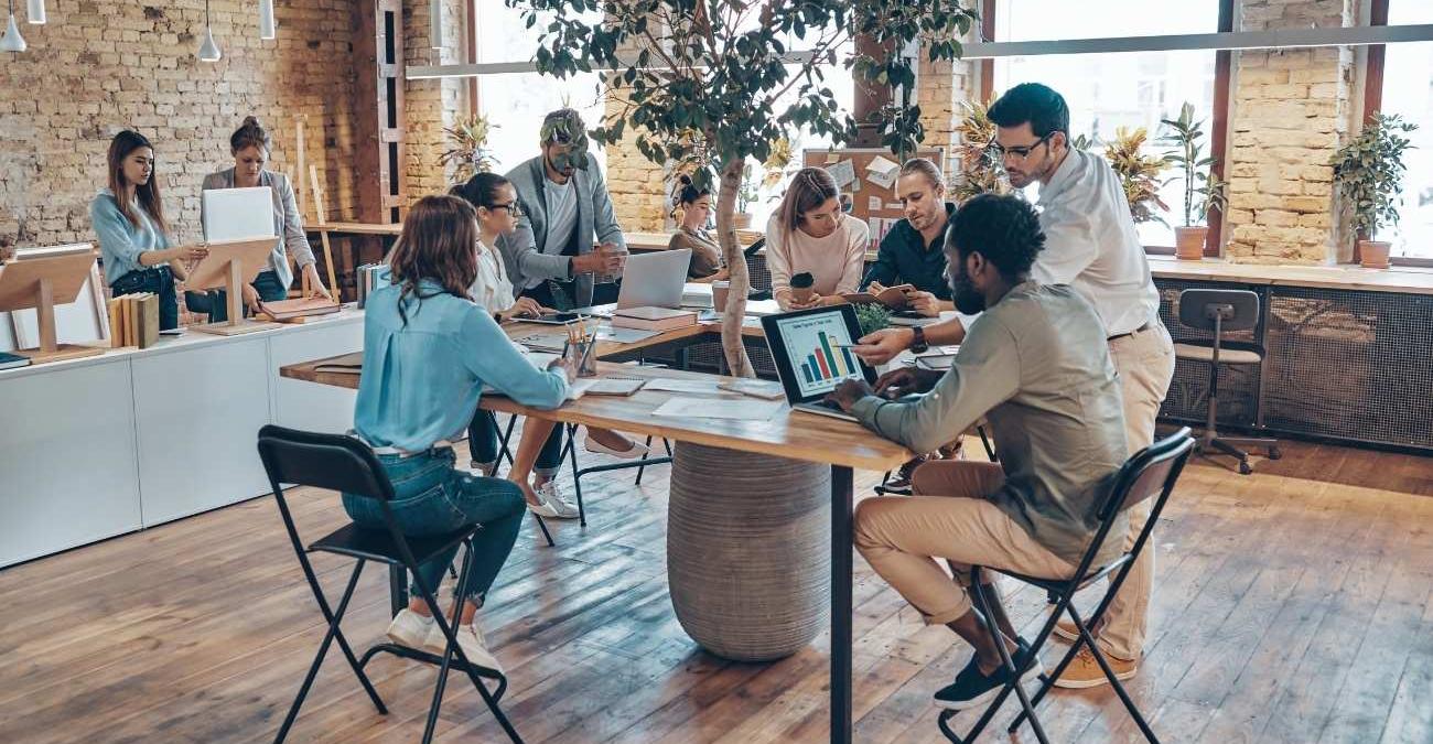Junge Fachkräfte besprechen sich im Büro an modernen Geräten – Sinnbild für die EO-Datenprozessierung, die Rohdaten in nutzbare Datenprodukte verwandelt.