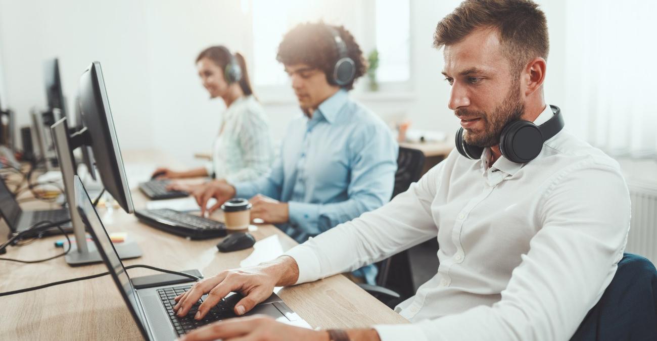 Ein IT-Spezialist arbeitet konzentriert an seinem Monitor und analysiert Systemdaten. Symbolbild für Second Level Support bei komplexen Softwareproblemen.