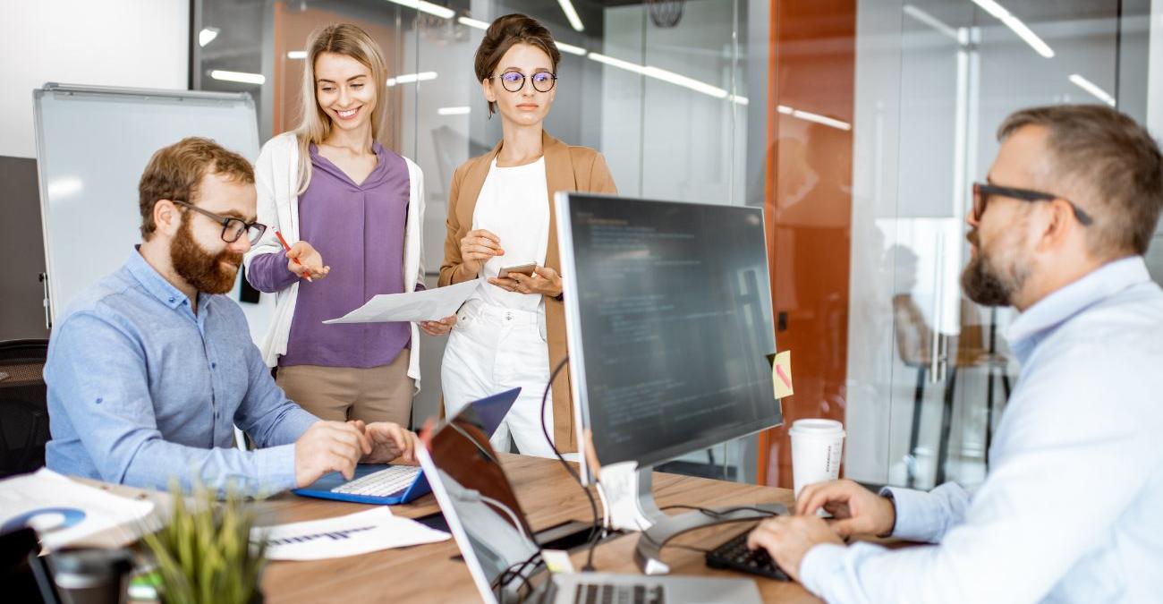 Vereinsvorstand und Entwicklerinnen besprechen die Anforderungen einer neuen Vereinssoftware am Tisch.