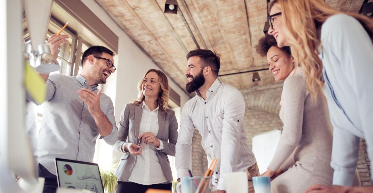 Das Team einer Software Agentur steht für das Daily Scrum Meeting im Kreis zusammen.