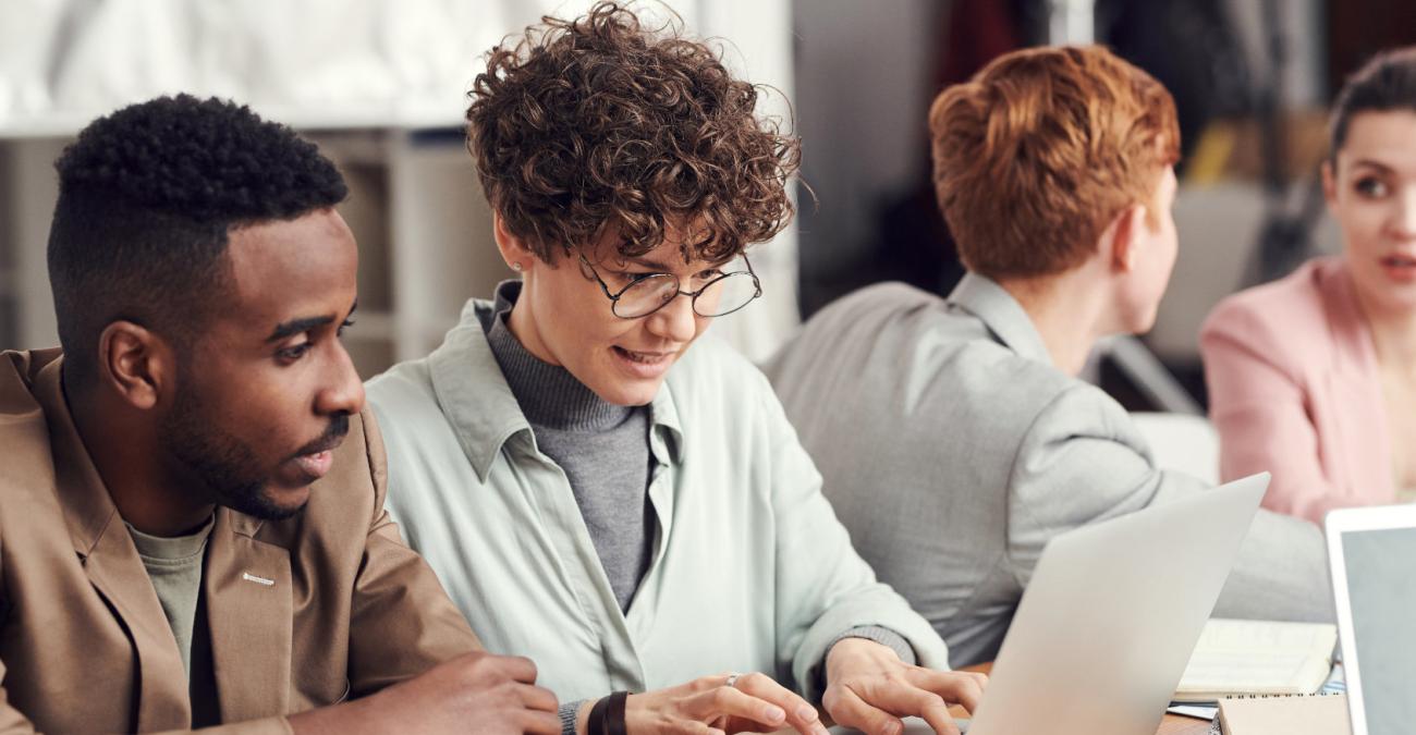 Zwei Menschen sitzen im Büro an einem Laptop