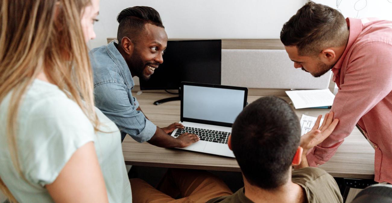 Vier Leute arbeiten gemeinsam am PC