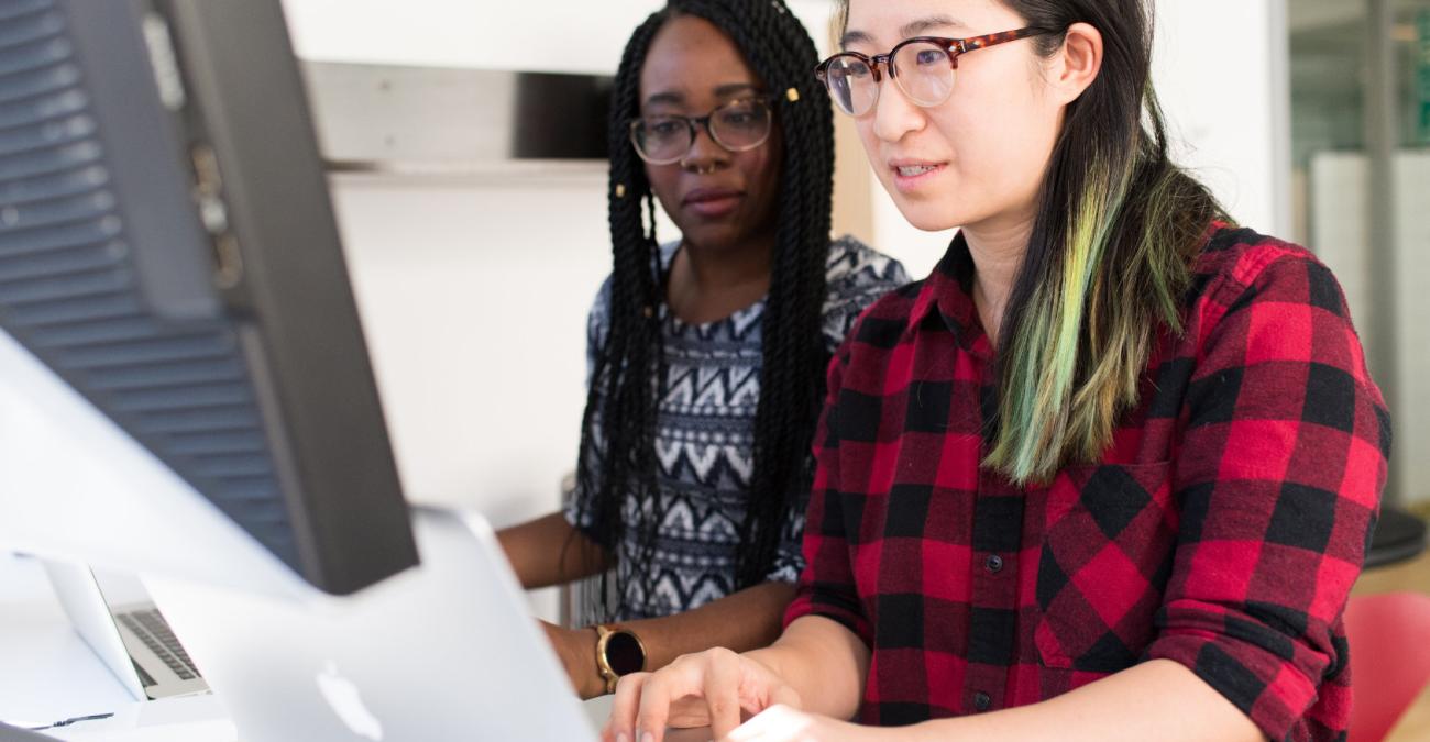 Zwei Menschen arbeiten gemeinsam an einem Computer