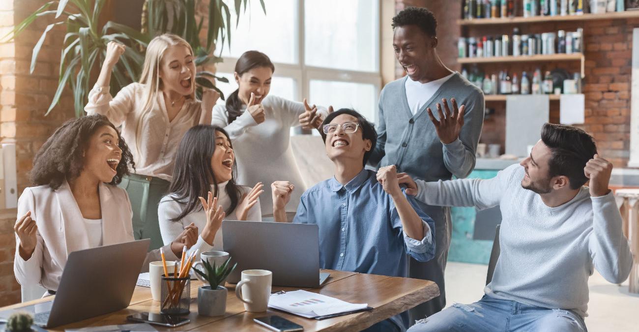 Team feiert im Büro der Firma Erfolg bei der Software-Entwicklung