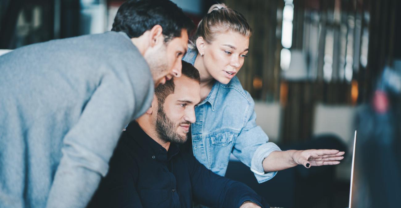 Im Büro: Drei Kolleginnen und Kollegen betreiben am Rechner Problemmanagement.