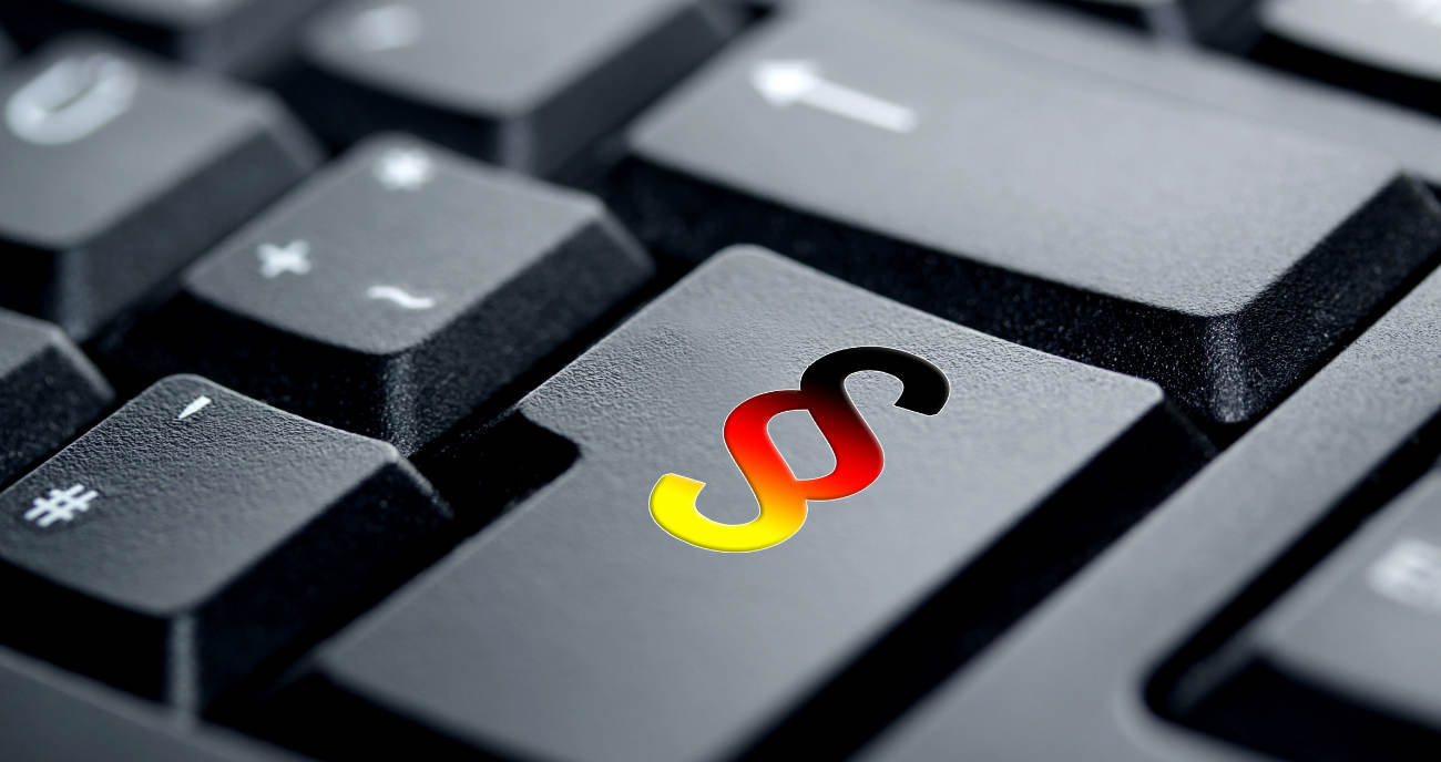 Die Tastatur eines Notebooks. Schwarz. Auf einer Taste ist in den Deutschlandfarben das Symbol für einen Paragrafen zu sehen. Ein Symbolbild für IT-Sicherheitsstrategie nach BSI-Standard.