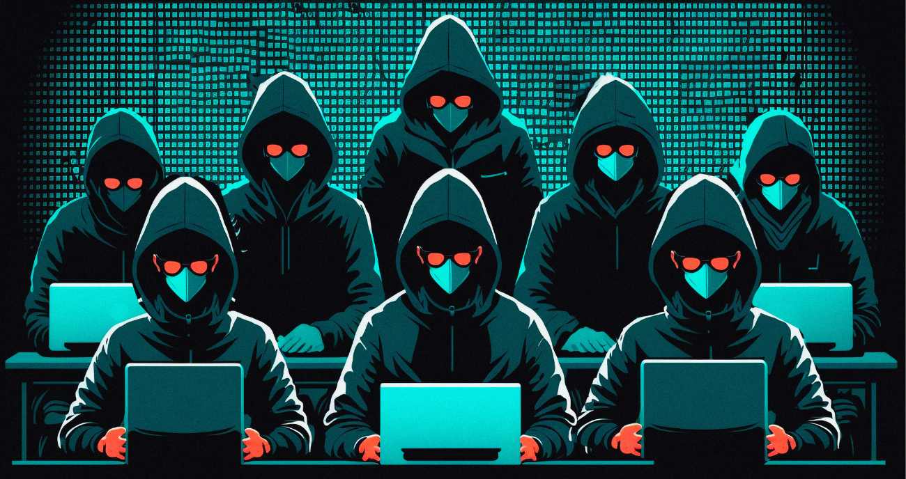 Cyberkriminelle sitzen vermummt an ihren Notebooks. Sie programmieren Ransomware.