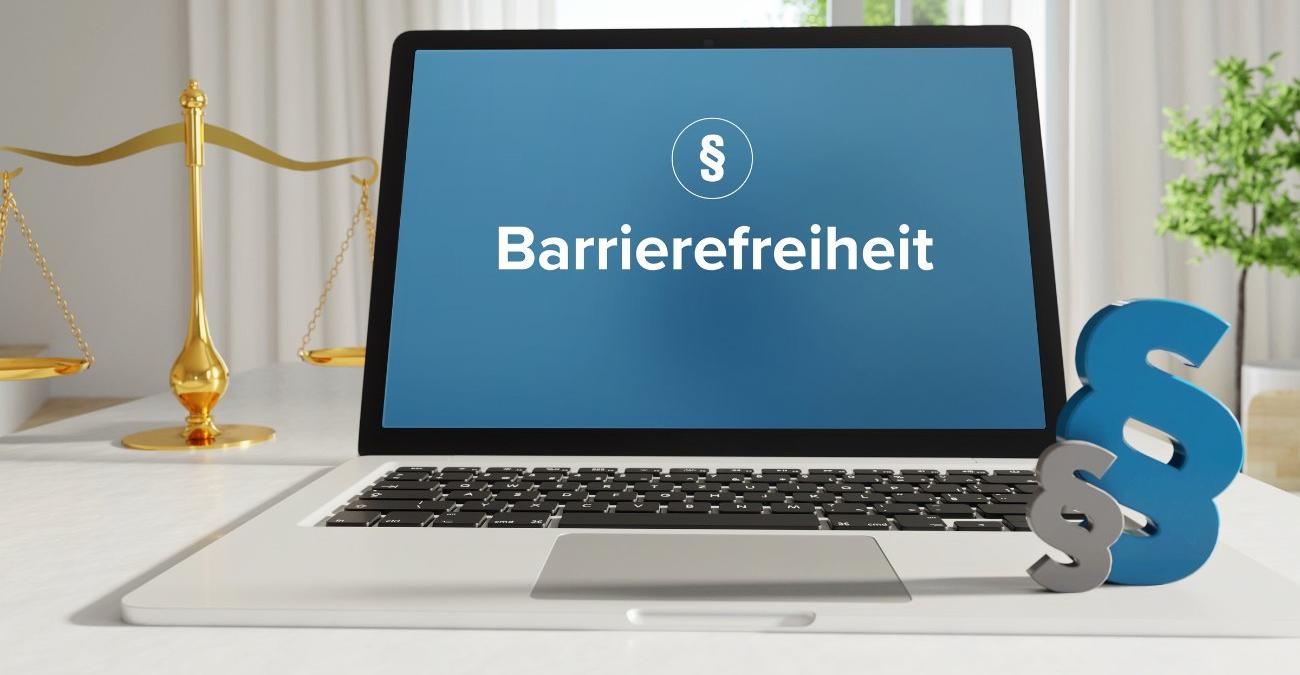Barrierefreies Webdesign Ein Notebook steht auf dem Tisch. Daneben eine Wage, die das juristische Recht symbolisiert. Auf dem Display steht: Barrierefreiheit. Ein Symbolbild für barrierefreies Webdesign.