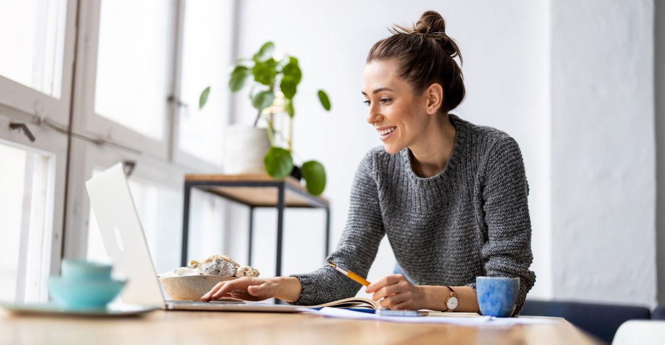 Eine junge, dynamische Frau sitzt an einem Laptop und entwickelt Software für ein gemeinnütziges Projekt im Rahmen von Charity Coding.