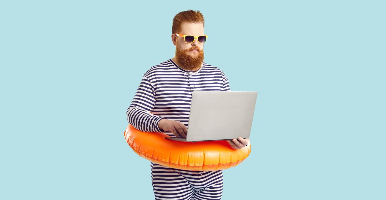 Blauer Hintergrund. Ein lässiger Typ mit rotem Bart und Schwimmanzug trägt einen bunten Rettungsring um die Hüften. Er hält ein Notebook in der Hand. Ein Symbolbild für das Joomla CMS.