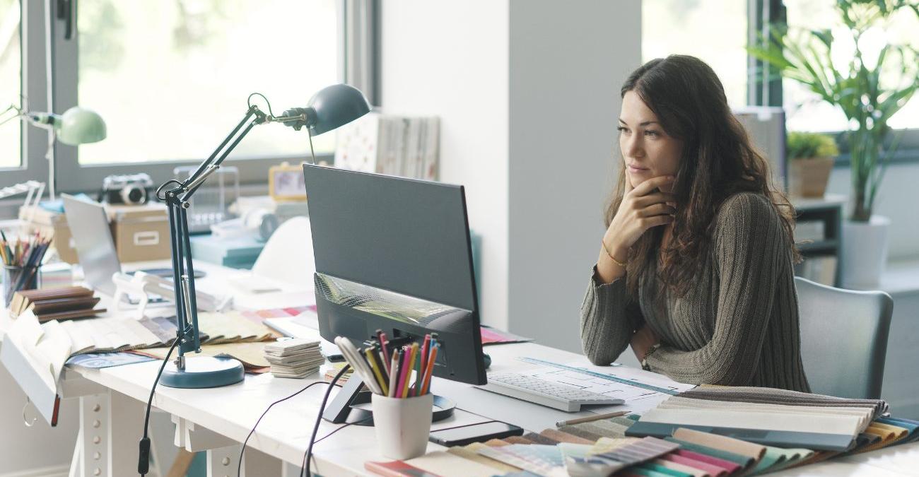 Eine Entwicklerin arbeitet konzentriert an einem Bildschirm mit einer CMS-Oberfläche. Ein Symbolbild für die Arbeit mit Contao.
