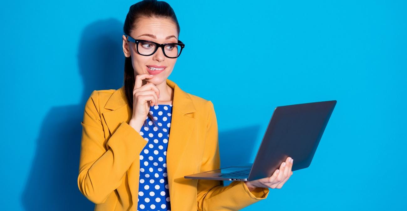 Porträt einer jungen Frau, die nachdenklich ein Notebook in den Händen hält. Sie entwickelt einen Plan für die IT-Verwaltung. Der Hintergrund ist leuchtend blau.