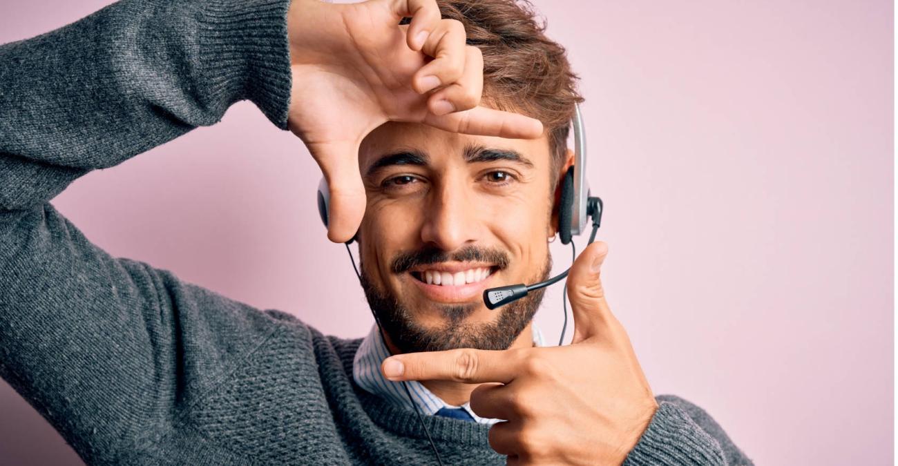 Ein Mitarbeiter eines Call Centers mit Headset freut sich über die bereitgestellte Software.